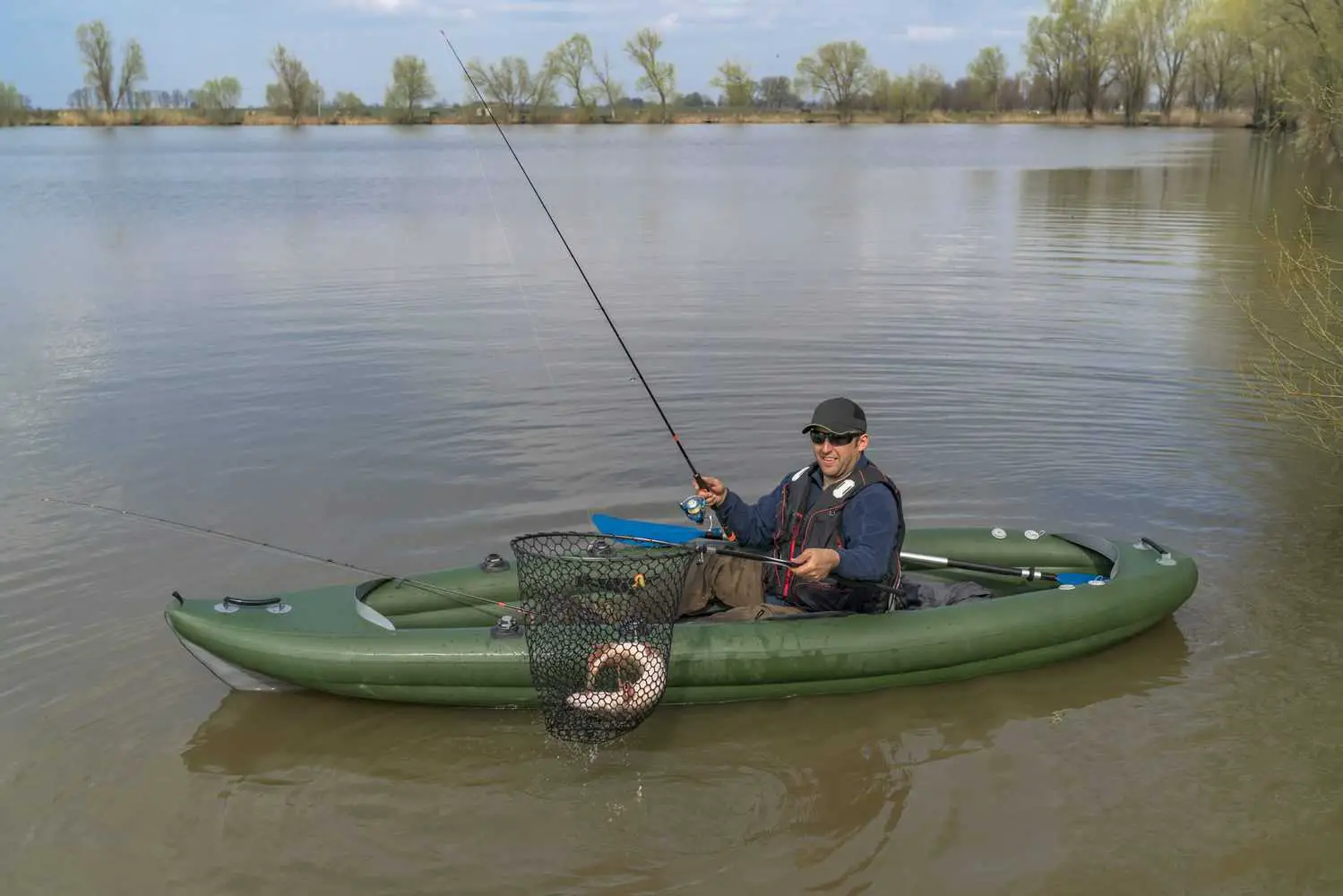 Man Catching Fish In Inflatable Kayak